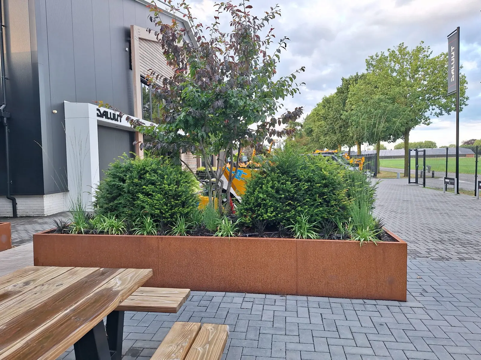 Cortenstaal borderbak met gelaagde beplanting langs de entree van het bedrijfspand van Dalukt
